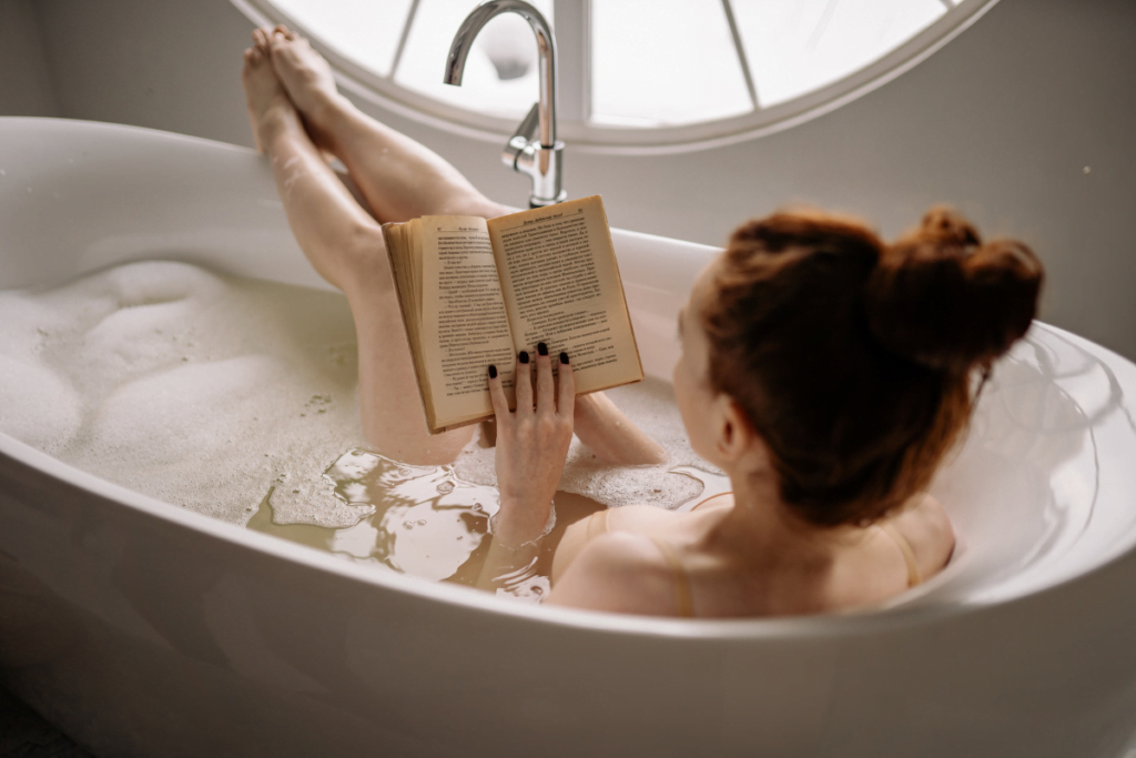 A woman enjoying a book in a renovated bathtub.