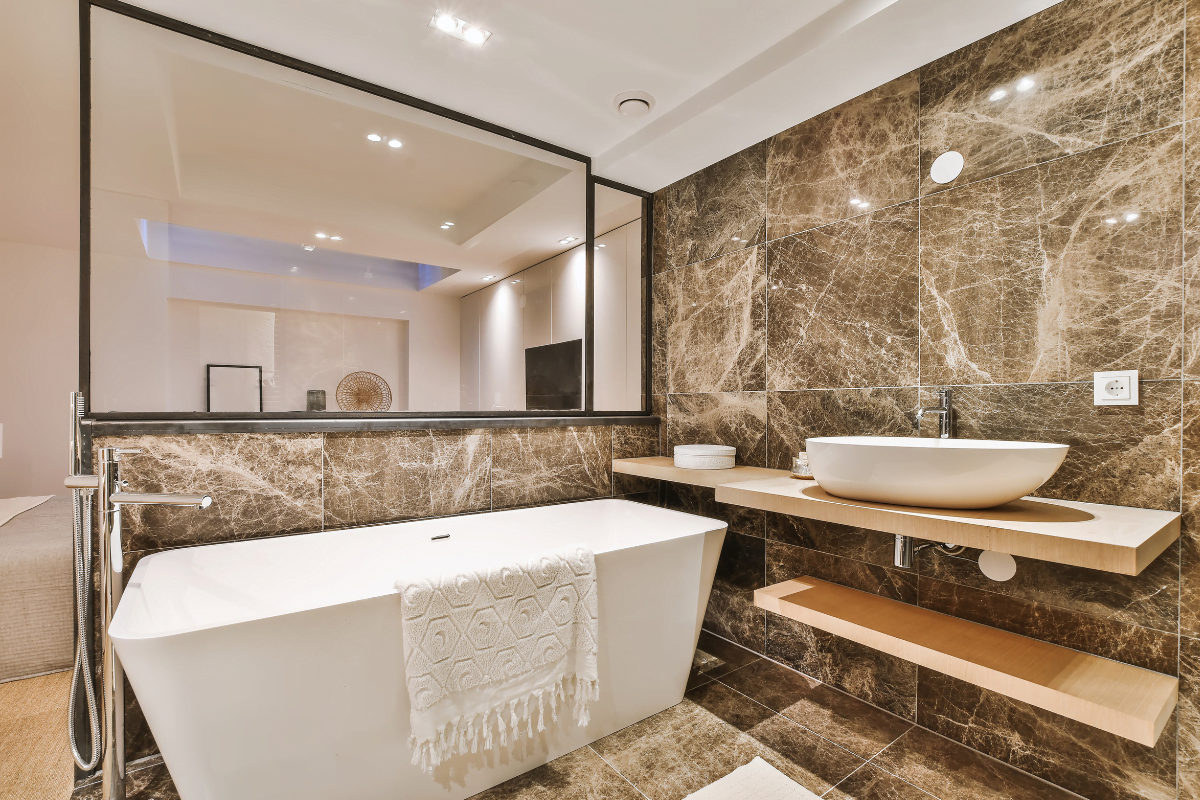 A bathroom with marble walls and a bathtub featuring bathroom upgrades that add value.