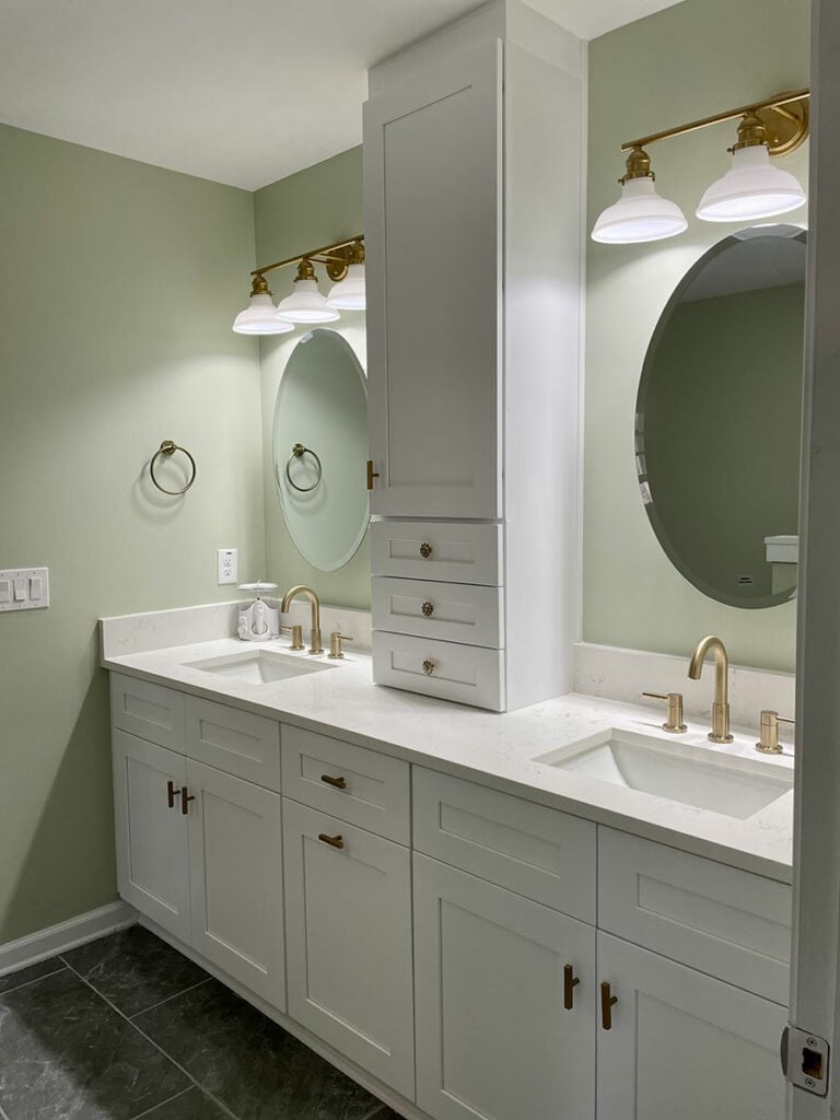 A remodeled bathroom with two sinks and a mirror designed by Zeus's Marietta remodeling services.