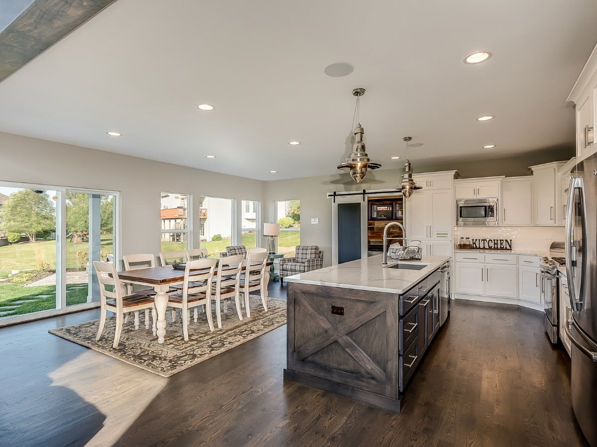 A large colonial style kitchen with hardwood floors and a dining area.