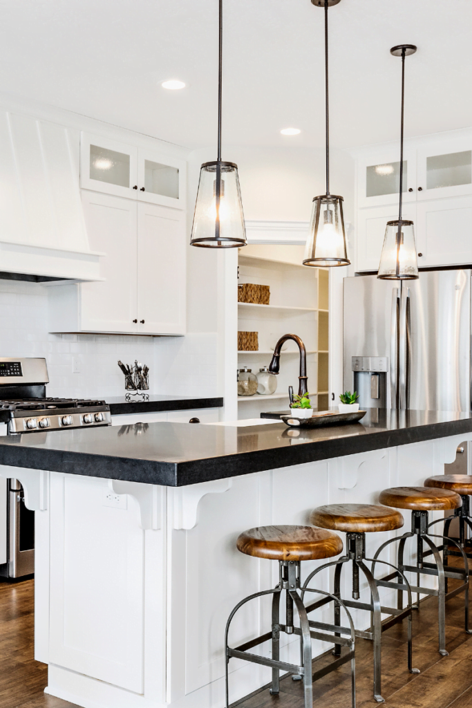 An Austell kitchen remodeling project featuring a sleek white design with black counter tops and stools.