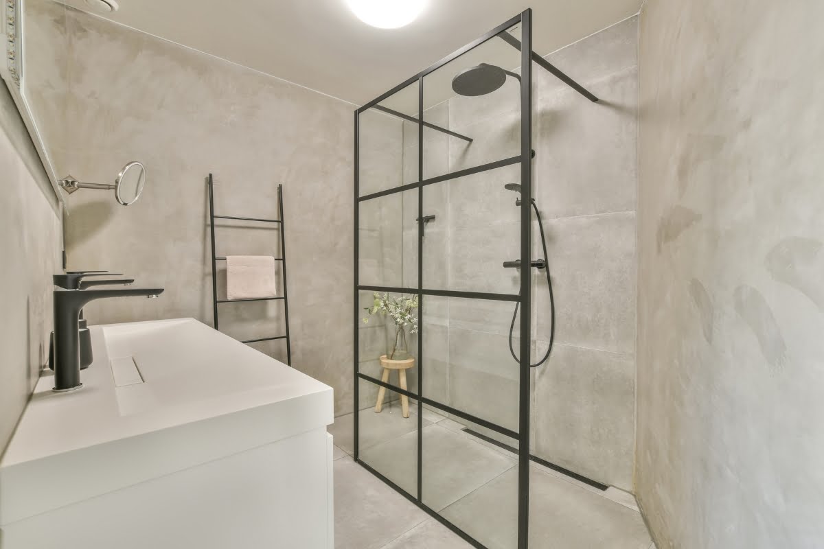 A modern wet room bathroom with a glass shower stall.