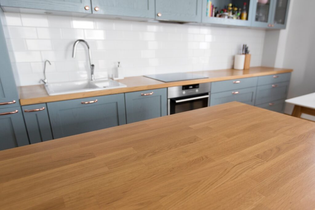 A wooden countertop in a white kitchen.