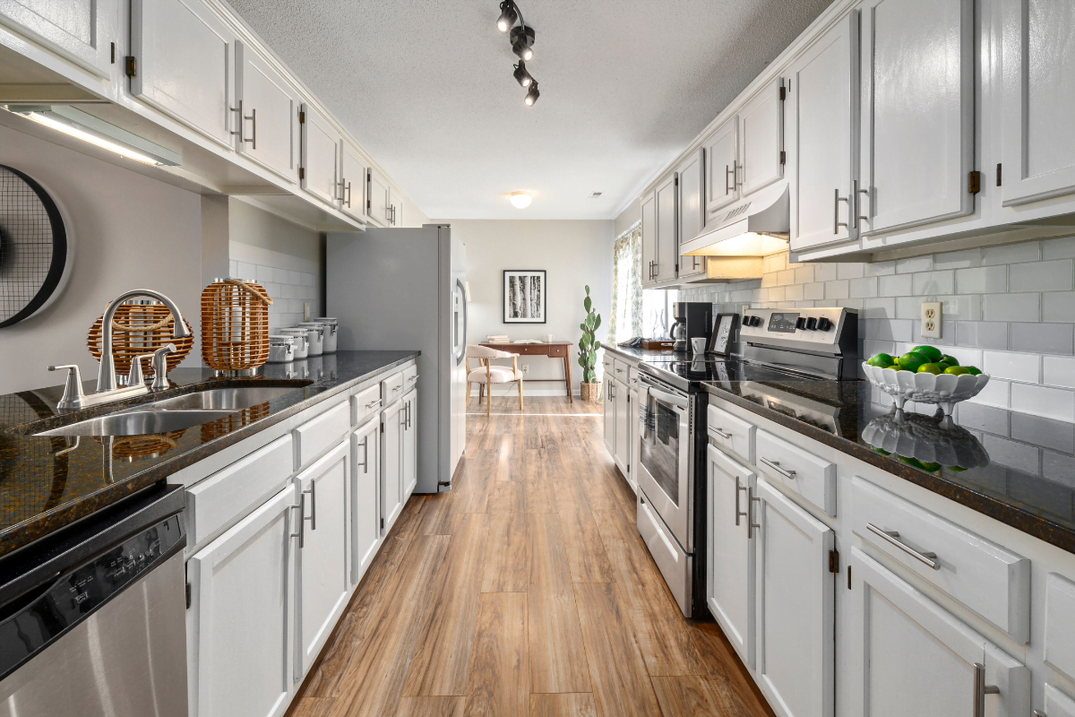 A modern kitchen with white cabinets and stainless steel appliances, following the latest kitchen trends.