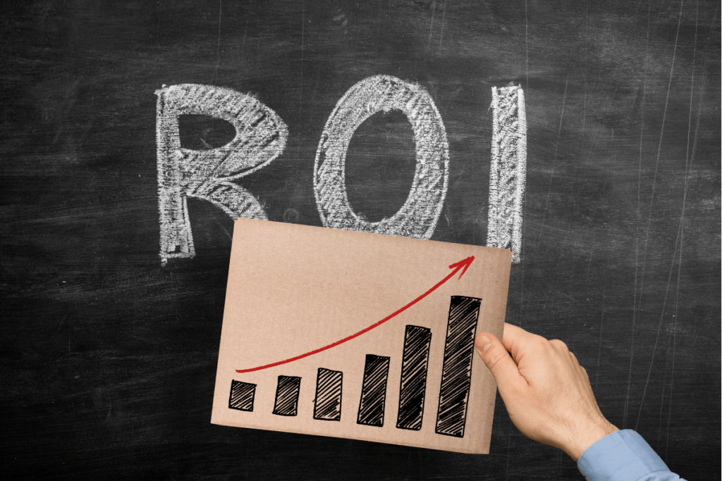 A hand holding a cardboard sign with a graph illustrating ROI from a kitchen remodel.