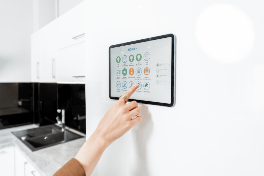 A hand touching a touch screen to adjust the lighting in the kitchen.