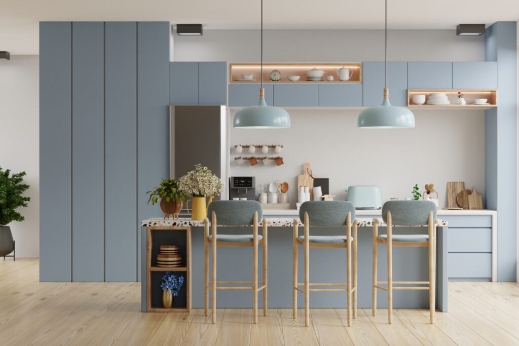 Kitchen maintenance tips for a modern interior with blue cabinets, wooden flooring, and a breakfast bar with three stools under pendant lights.