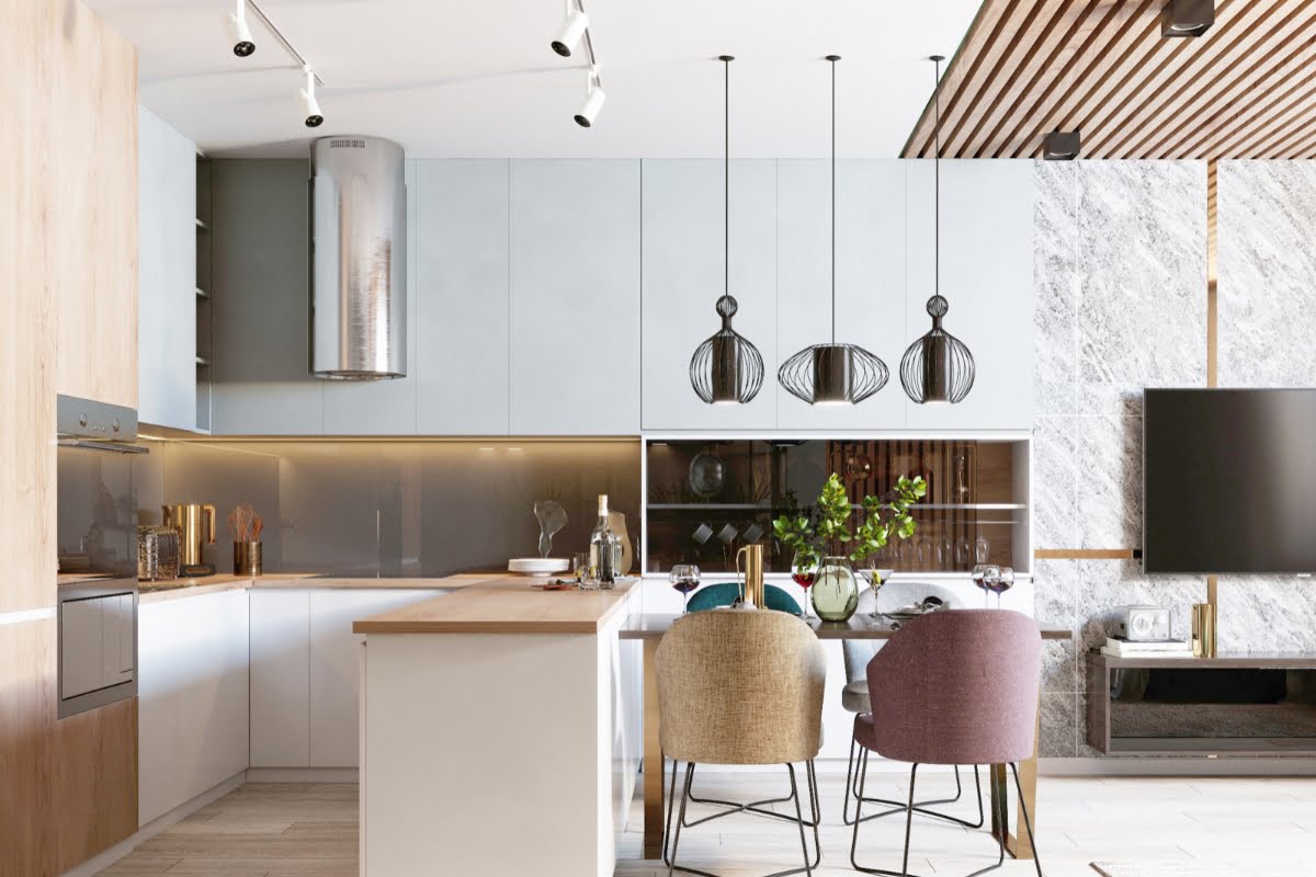 Modern kitchen design trends shine in this space, featuring light wood and white cabinets, a wooden island with bar seating, pendant lights, and a dining area with pastel-colored chairs. The room offers a marbled wall and a mounted TV.