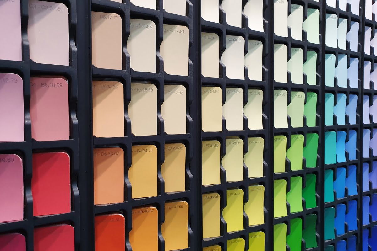 A multicolored display of paint swatches arranged in vertical rows, showing a gradient from warm shades on the left to cool shades on the right, embodies healthy home design by harmonizing color palettes for a balanced living space.