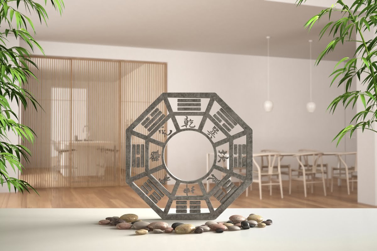 A decorative octagonal structure with Chinese characters is displayed indoors on a table surrounded by rocks. The background showcases a minimalist room with wooden furniture and green plants, embodying the principles of healthy home design.