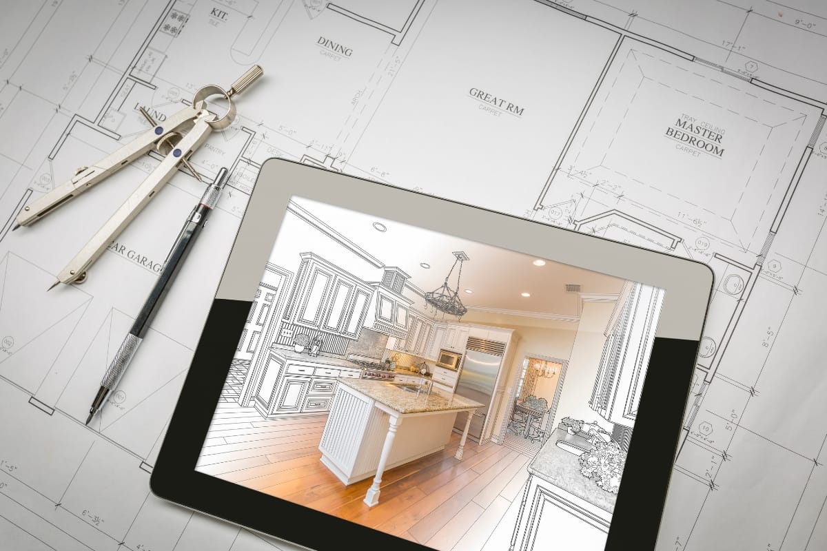 A tablet showcasing a vintage style kitchen design sits on architectural floor plans. Nearby, a compass and pen add to the creative scene.