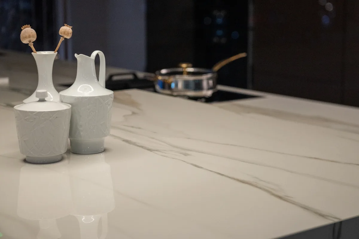 Top Kitchen Countertop Options for Your Sandy Springs Remodel 33 Ceramic vessels adorn the marble kitchen countertop, while a metal pot simmers gently on the stove in the background. It's a charming scene that homeowners in Sandy Springs would cherish, blending functionality with elegance effortlessly.