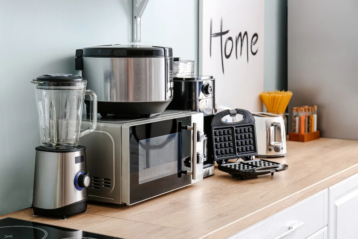 Top Kitchen Countertop Options for Your Sandy Springs Remodel 25 The kitchen countertop in Sandy Springs features a range of appliances, including a blender, pressure cooker, coffee maker, microwave, waffle maker, and toaster—perfect for homeowners exploring kitchen countertop options.