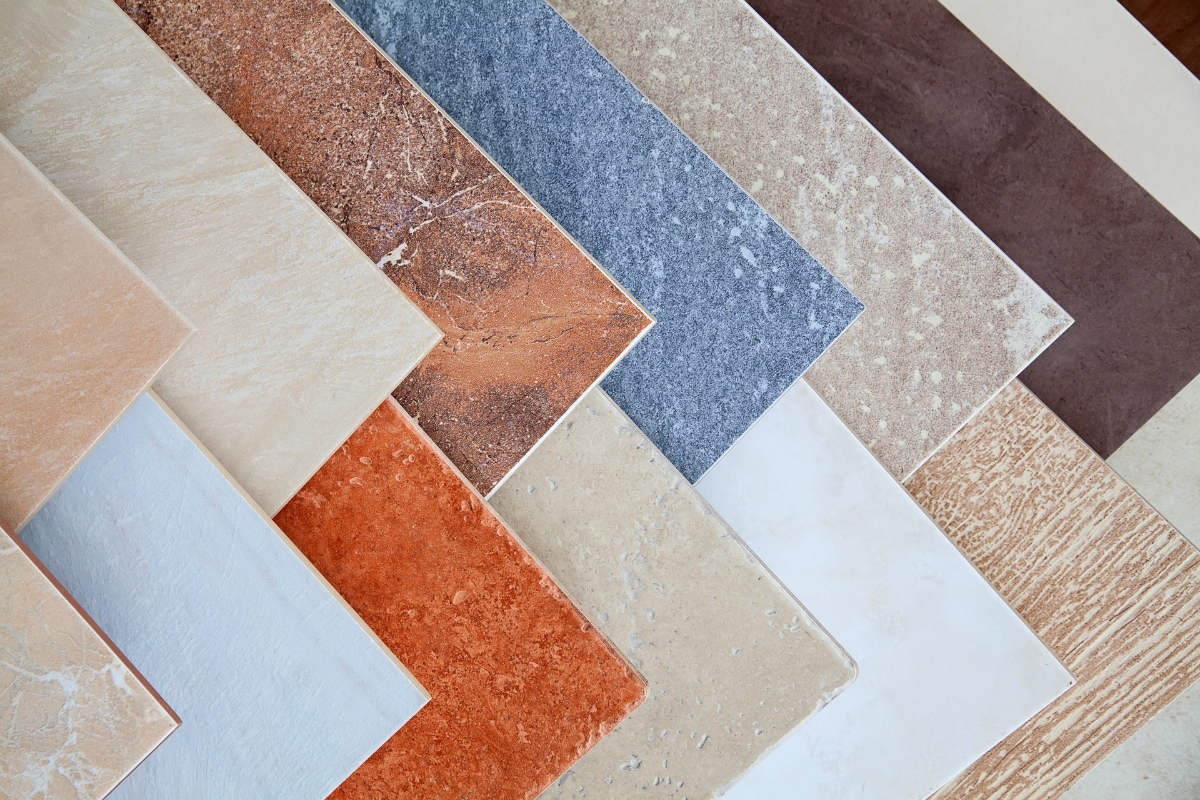 Bathroom Tile Flooring in Vinings: Expert Tips, Trends, and Benefits 3 A selection of rectangular ceramic tiles ideal for bathroom tile flooring, offered in various colors and textures—beige, orange, blue, brown, and cream—arranged in a staggered overlapping pattern.
