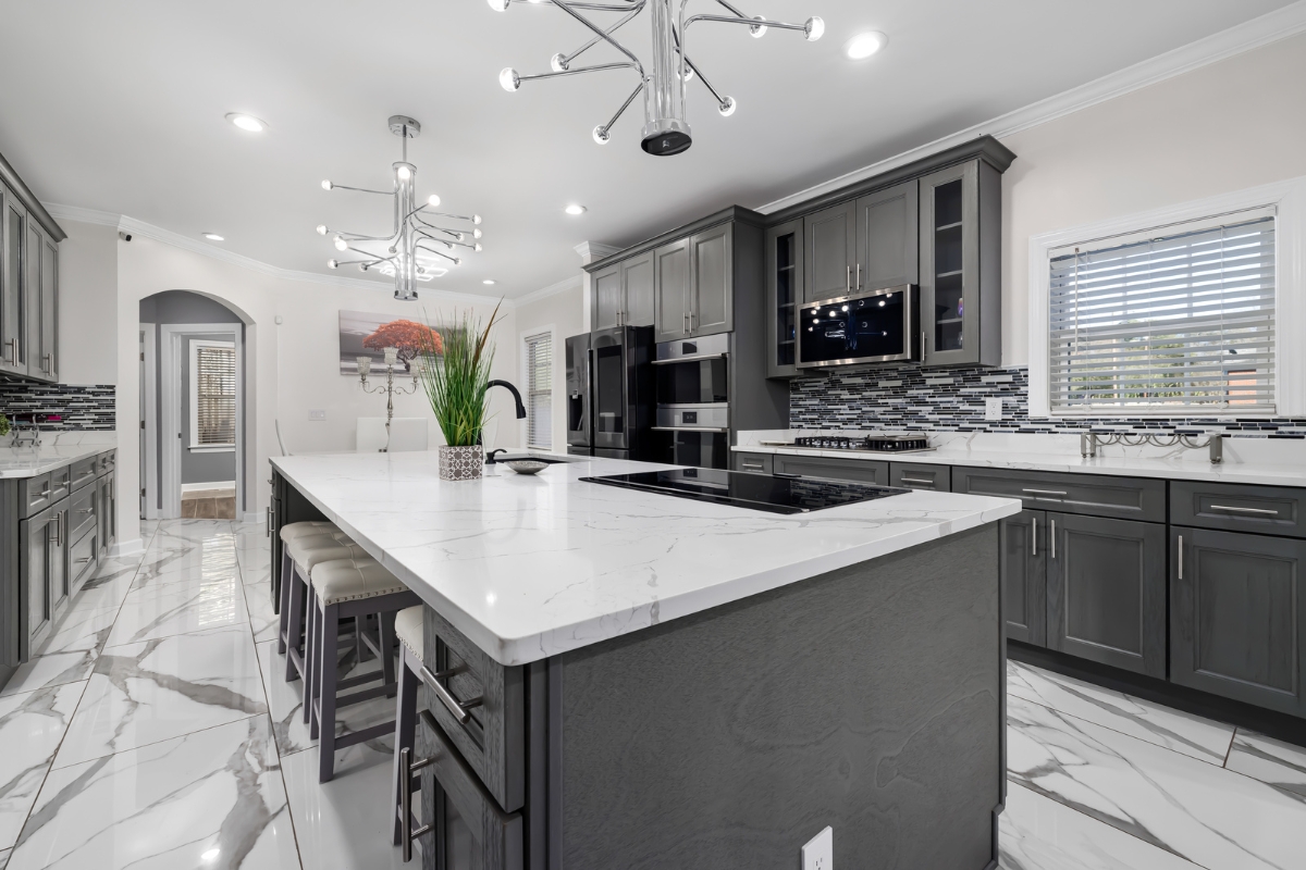 Custom Kitchen Storage Solutions in Kennesaw: Maximize Your Space 7 Modern kitchen with dark gray cabinets, marble countertops, custom kitchen storage, a large center island with stools, stainless steel appliances, and geometric tile flooring.