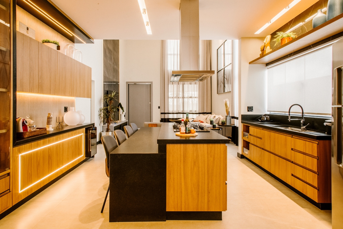 Luxury Kitchen Remodeling in Buckhead: Must-Have Features for 2025 5 Modern luxury kitchen remodeling with wood cabinets, black countertop island, built-in appliances, and bar stools, brightly lit by natural and recessed lighting.