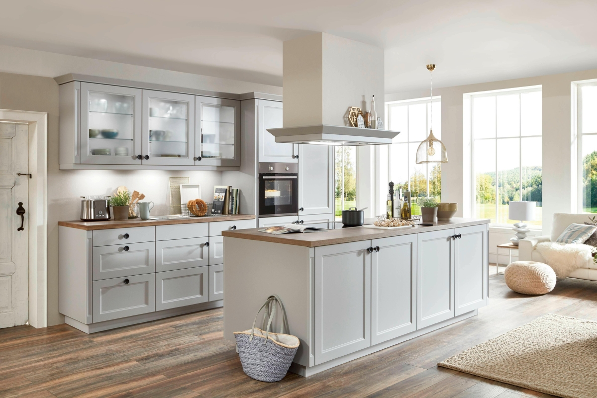 Eco-Friendly Kitchen Remodeling in Smyrna: Sustainable Upgrades That Last 12 Modern kitchen with light gray cabinets, wooden countertops, a central island, and large windows. Eco-friendly kitchen remodeling features fill the space with natural light, while appliances and decor are arranged neatly.
