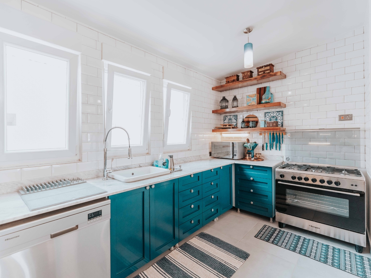 Upscale Small Kitchen Design Ideas for Every Budget 7 Modern kitchen with turquoise cabinets, stainless steel appliances, open wooden shelves, and a tiled backsplash—perfect inspiration for Small Kitchen Design Ideas, featuring three windows that flood the space with natural light.