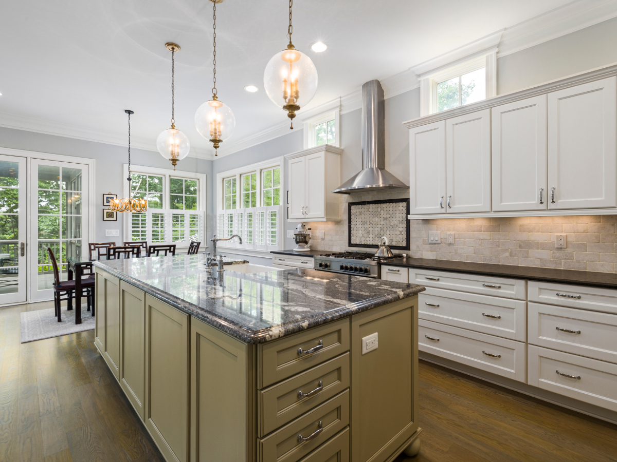 Kitchen Staging Ideas to Wow Potential Buyers: Expert Tips for Effective Home Selling 3 Modern kitchen with white cabinets, a large island with granite countertop, stainless steel appliances, pendant lights, and dining area by large windows—perfect for showcasing top staging ideas.